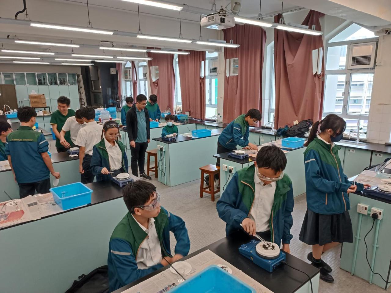 周四聯課活動(科學探索小組)(2026-27) 學生們用檸檬汁在紙上寫字，風乾後無痕，再以電熱板輕烤，字跡便因焦化反應而浮現，如解密般驚喜又有趣。