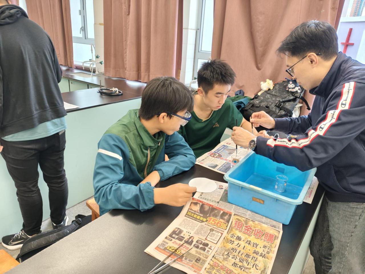 周四聯課活動(科學探索小組)(2026-27) 學生們用檸檬汁在紙上寫字，風乾後無痕，再以電熱板輕烤，字跡便因焦化反應而浮現，如解密般驚喜又有趣。